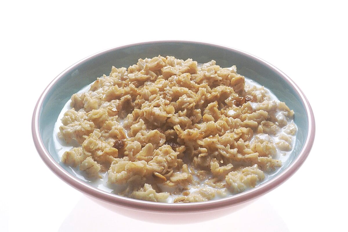 Tazón blanco con avena cocida sobre fondo claro